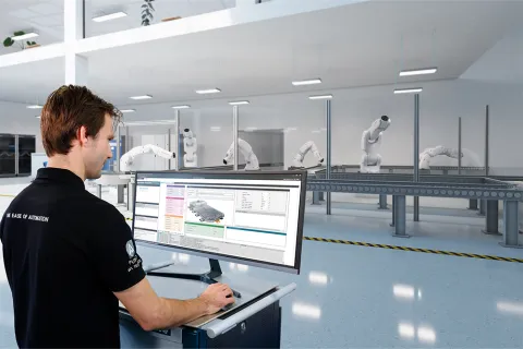 Man standing at a trolley operating production software